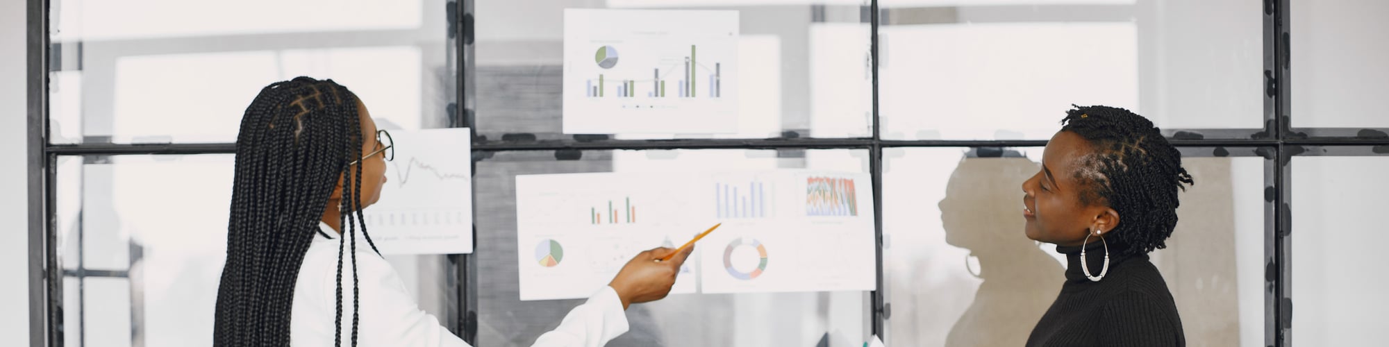 Two women discussing graphs and charts