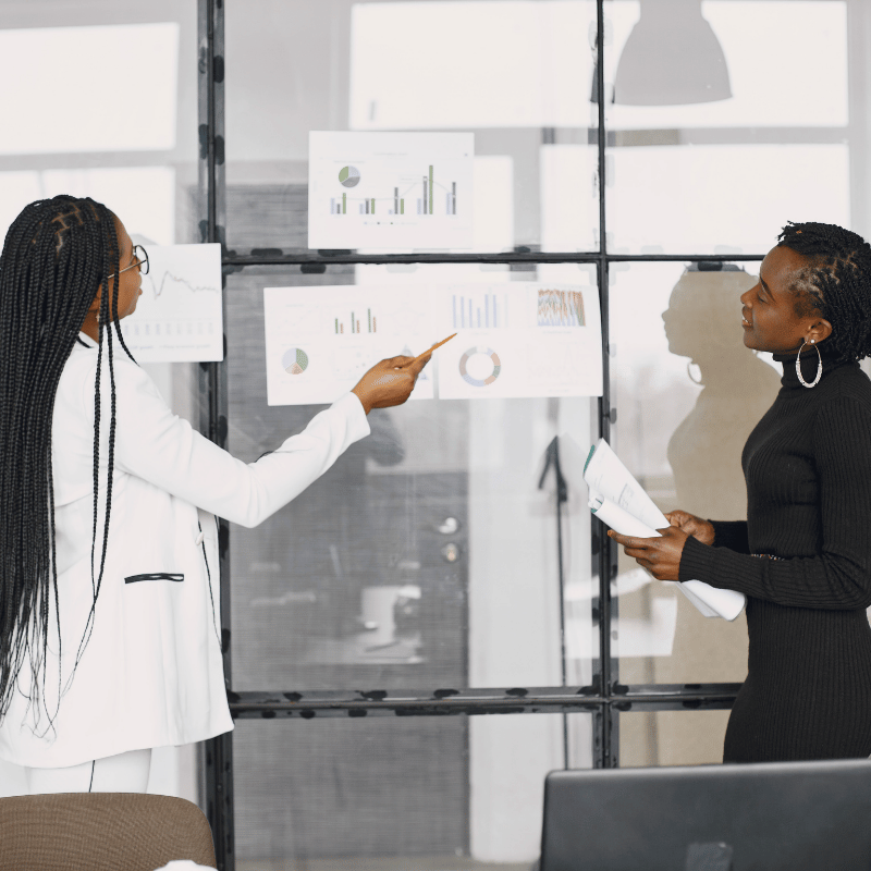 Two women discussing while looking at charts