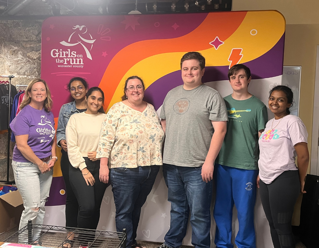 A group of people standing next to each other in front of a wall