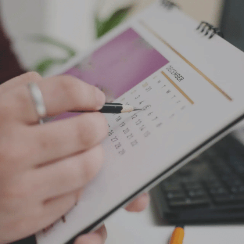 An up-close image of a person circling a date on a calendar